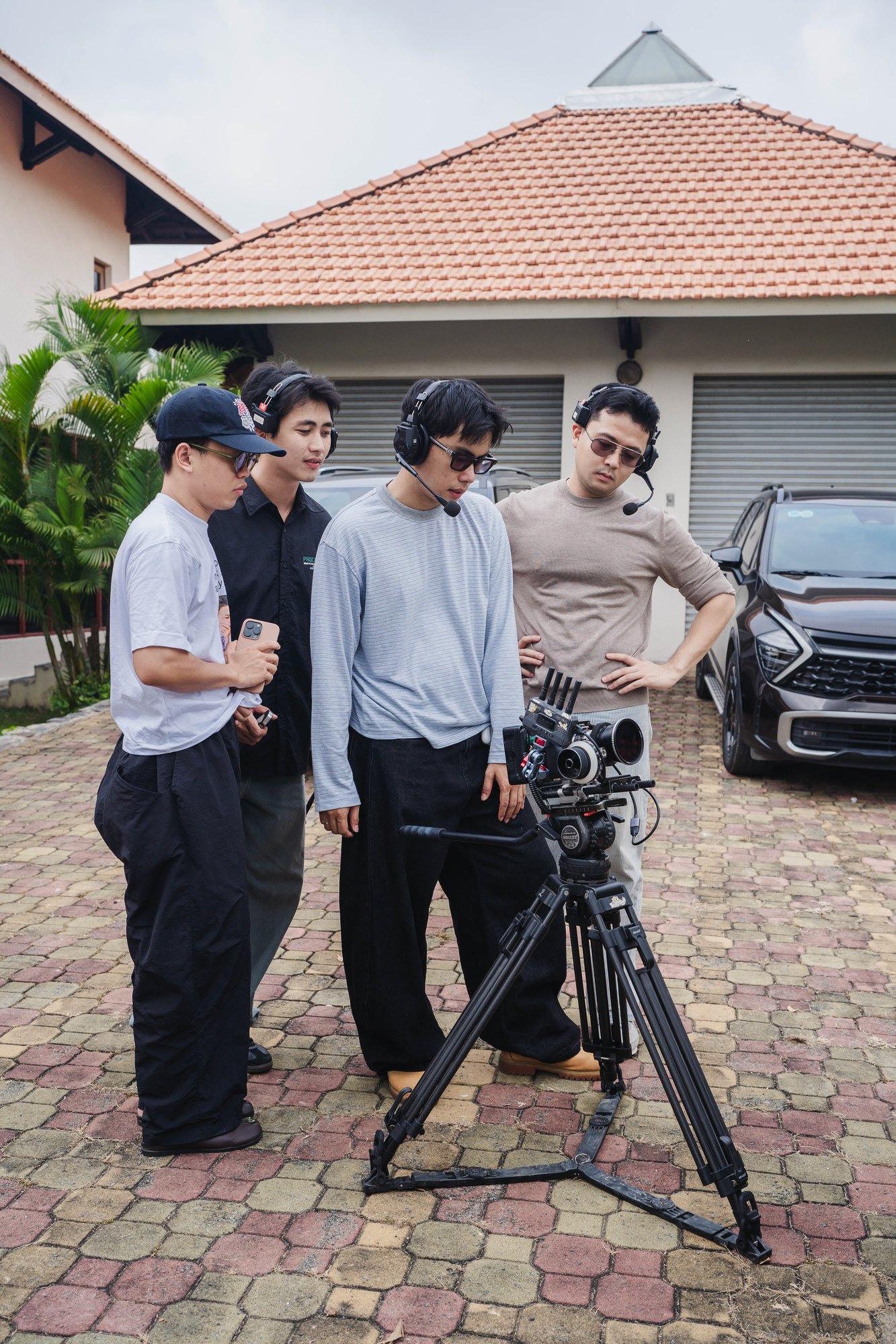 Crew directing talent beside a car in daylight