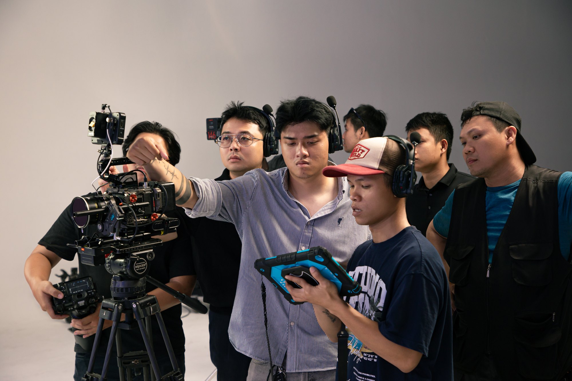 SK Production crew gathered around the camera on set
