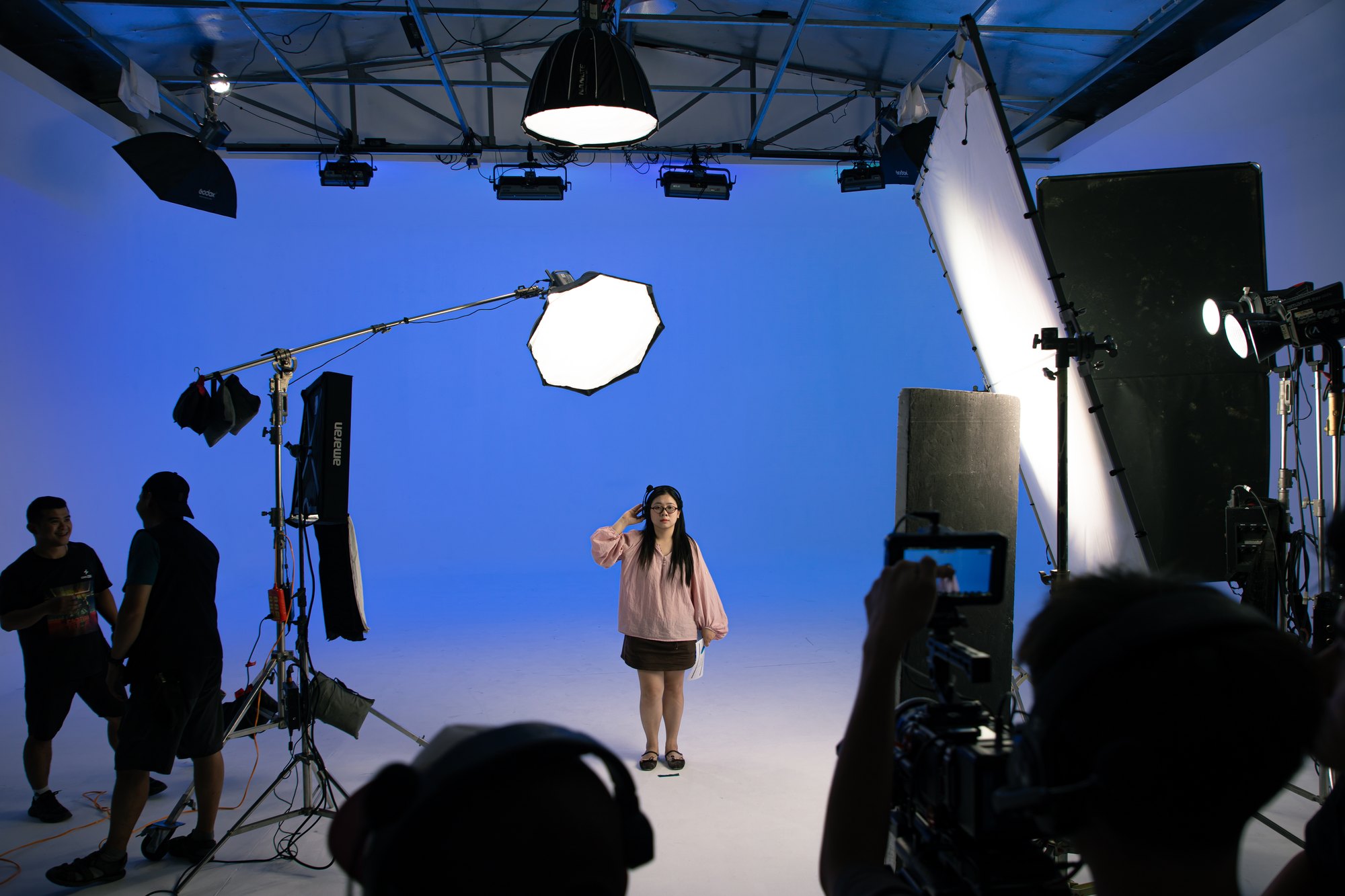 Talent lit on the blue cyclorama with boom and softbox